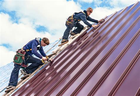 A Metal Roof Is Being Installed On Top Of A House A Metal Roof Is Being Installed On Top Of A House